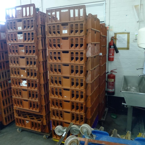 294 - 41 stacking plastic bread trays and 2 wheeled skates (mainly terracotta coloured)