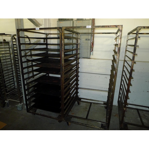 314 - 2 metal wheeled bakers racks - one of which contains a quantity of metal trays