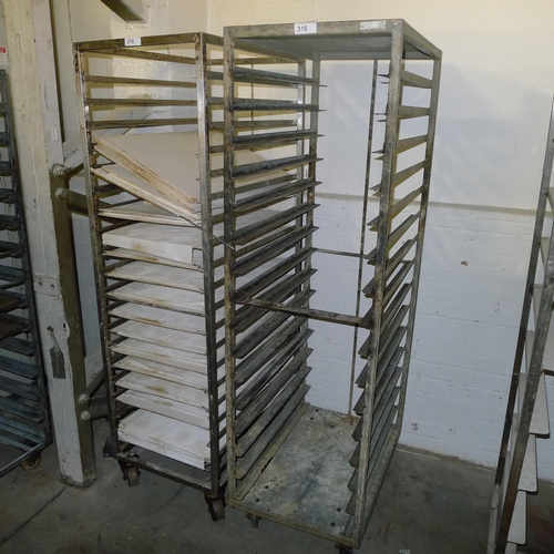 316 - 2 metal wheeled racks, one of of which contains a quantity of white flat doughnut slip trays