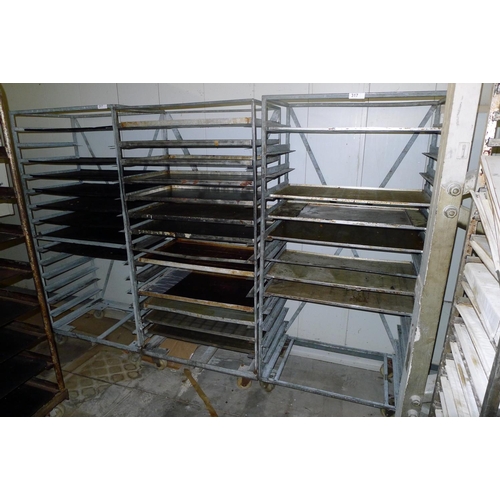 317 - 3 metal wheeled bakers racks each containing a quantity of metal trays