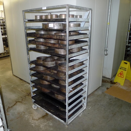 319 - 1 metal wheeled bakers rack containing a quantity of metal trays and tins