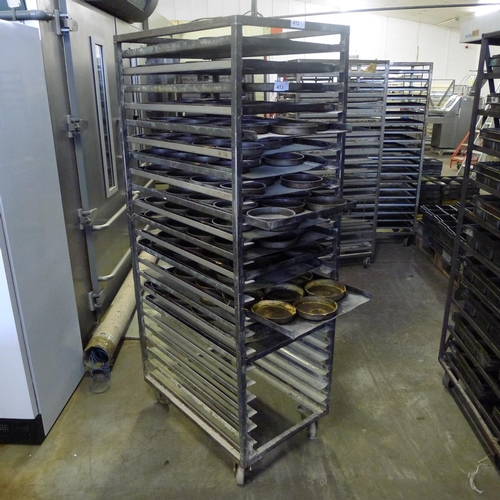 413 - 1 wheeled metal bakers rack containing a quantity of metal trays & round tins