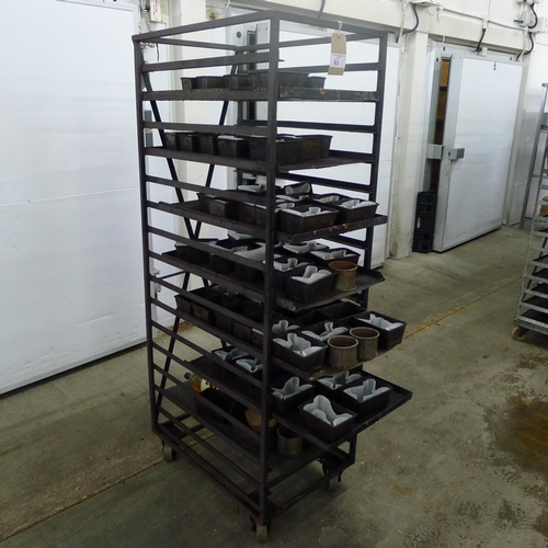 93 - 1 metal wheeled bakers rack containing a quantity of metal trays and tins