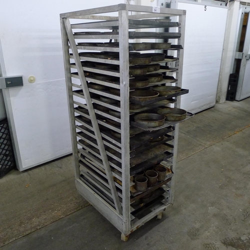 94 - 1 metal wheeled bakers rack containing a quantity of metal trays and tins