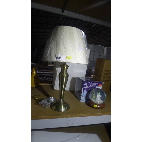 4186 - 1 metal table lamp with a cream shade, approx 63cm high including shade