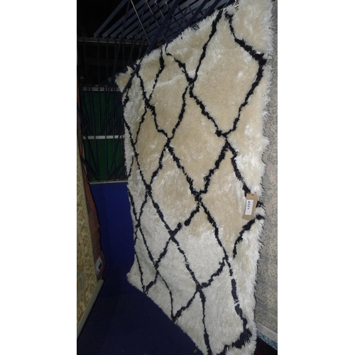 4521 - A cream and black patterned rug approx 120x170cm