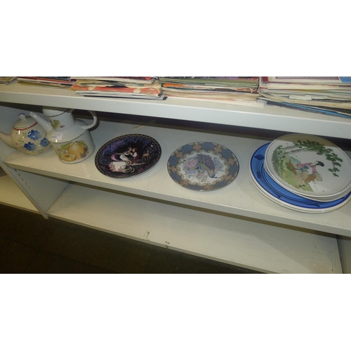 3107 - Two decorative teapots and several decorative plates (one shelf)