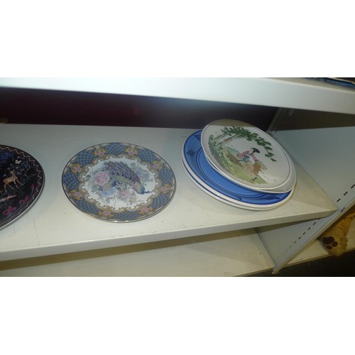 3107 - Two decorative teapots and several decorative plates (one shelf)