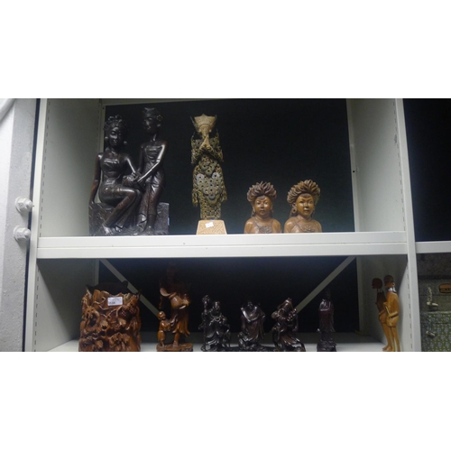 3138 - A quantity of miscellaneous oriental carved hardwood figures (2 shelves)