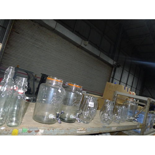 1030 - A quantity of various glass drink dispensers, jugs and bottles, contents of one shelf