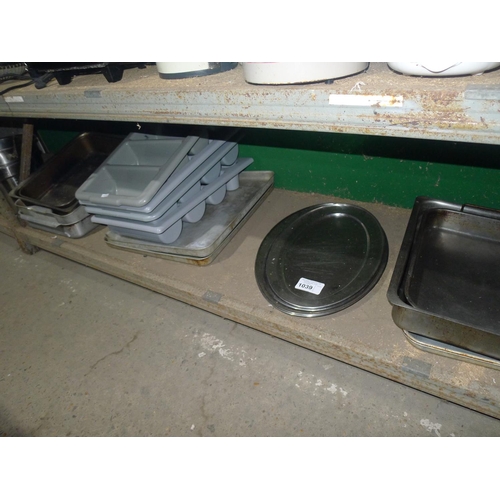 1039 - A quantity of various baking trays, serving trays, cutlery trays etc. Contents of one shelf