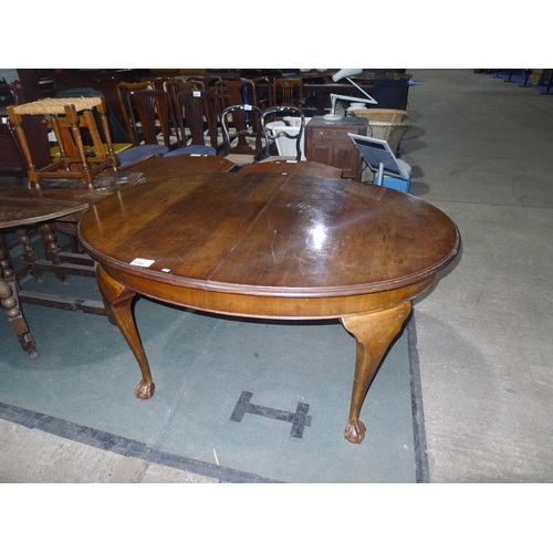 3384 - An oval extending dining table on cabriole legs with ball and claw feet