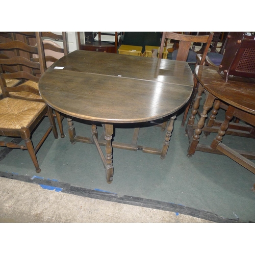 3387 - An oval Oak drop-leaf gate leg table on turned supports