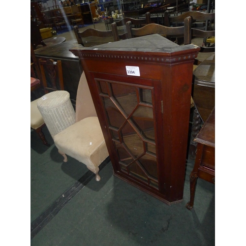 3394 - A Mahogany wall hanging corner cabinet with an astral glazed door in closing shaped shelves