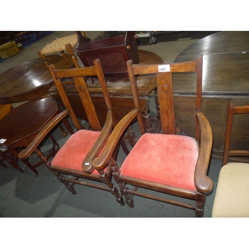 3397 - A pair of oak elbow chairs with pink lift out seats