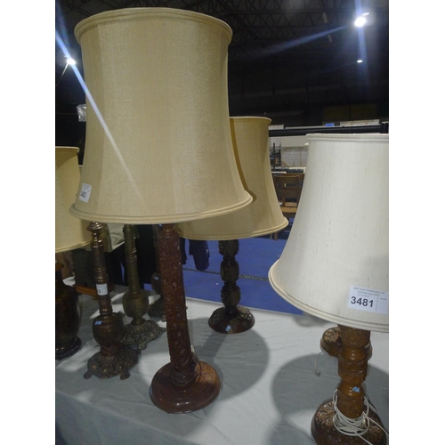 3482 - Two heavily carved oriental hardwood table lamps with shades