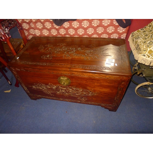 3524 - A heavily carved oriental camphor wood chest with a lift lid, approximately 100 cm wide