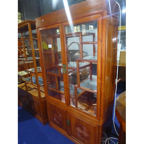 3535 - A carved oriental hardwood display cabinet with two glazed doors enclosing glass shelves, approximat... 