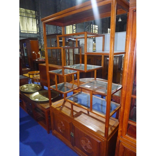 3536 - A carved oriental hardwood display stand with glass shelves and lower cupboards,  approximately 101c... 