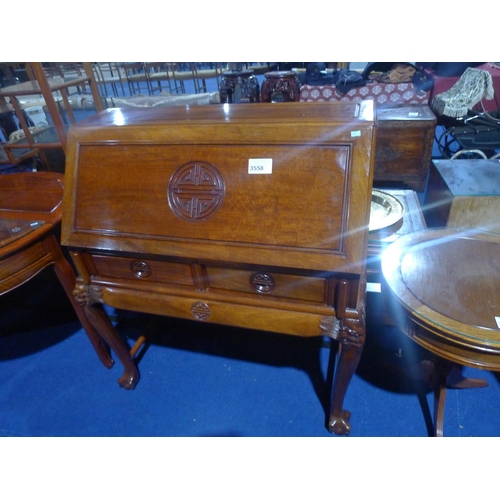 3558 - An Oriental carved hardwood bureau with a fall front enclosing a fitted interior with two drawers un... 