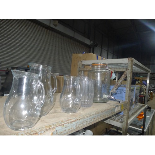 1030 - A quantity of various glass drink dispensers, jugs and bottles, contents of one shelf