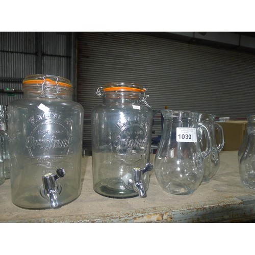 1030 - A quantity of various glass drink dispensers, jugs and bottles, contents of one shelf