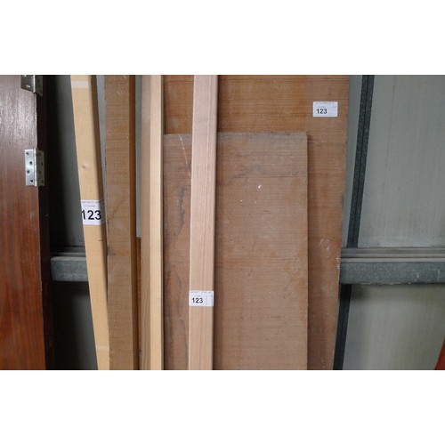 123 - A quantity of various lengths of wood including a sawn board at approx 305cm long x 48cm wide x 3cm ... 