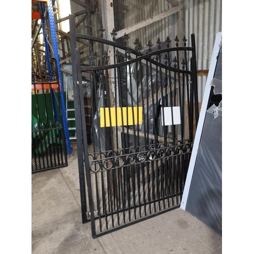 1089 - A pair of black painted ornate metal gates and two metal concrete in gate posts, each gate is approx... 