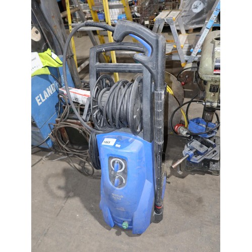 1065 - A Nilfisk Alto pressure washer type P150-1, 240v and a length of yellow garden plastic hose on a woo... 