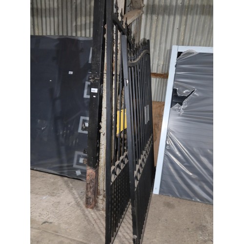 1089 - A pair of black painted ornate metal gates and two metal concrete in gate posts, each gate is approx... 