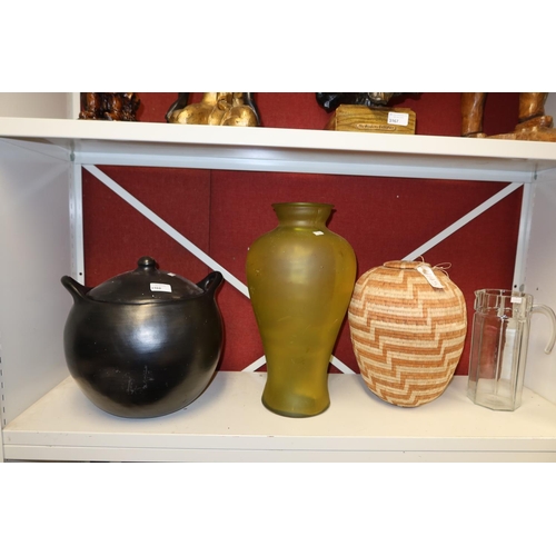 3168 - An African tribal basket, a tall green glass vase, a black pottery cauldron with lid and a glass jug