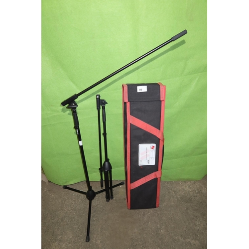 80 - 2 tall black metal folding tripod microphone stands by K & M supplied with a soft carry / storage ba... 