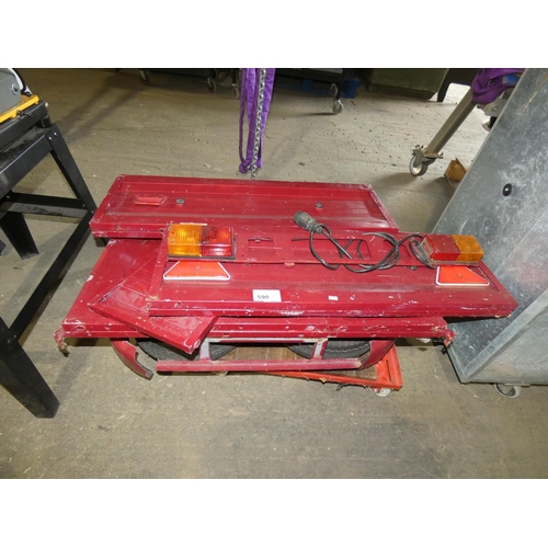 590 - A small red metal portable trailer. This trailer is flat packed to allow for easy storage and requir... 