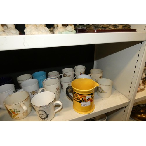 3034 - A collection of royal commemorative mugs and similar china (two shelves)