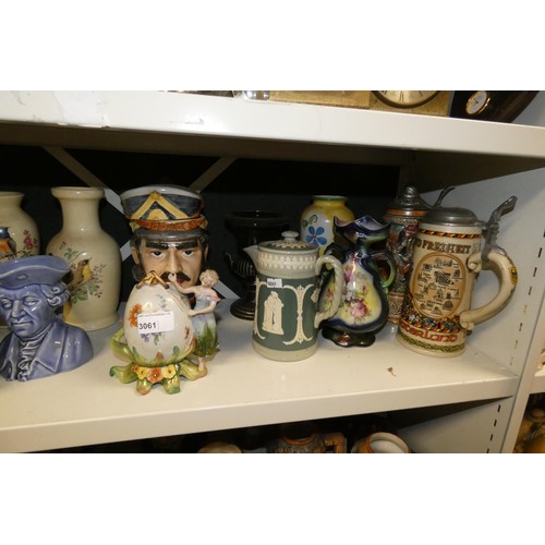 3061 - A quantity of miscellaneous decorative beer steins, Toby & character jugs and vases etc (three shelv... 