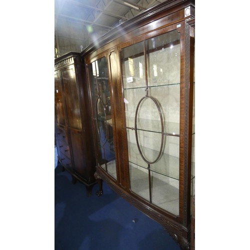 3490 - A large mahogany display cabinet with two glazed doors enclosing glass shelves on carved cabriole le... 