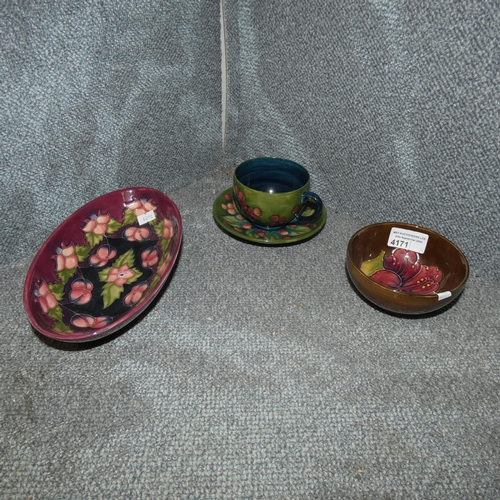 4171 - A green ground Moorcroft cup and saucer, a brown floral patterned Moorcroft bowl and a purple floral... 