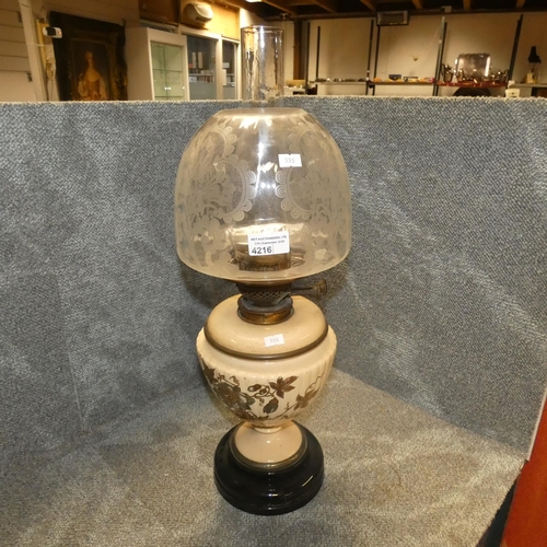 4216 - An Edwardian decorative floral patterned oil lamp with engraved glass shade