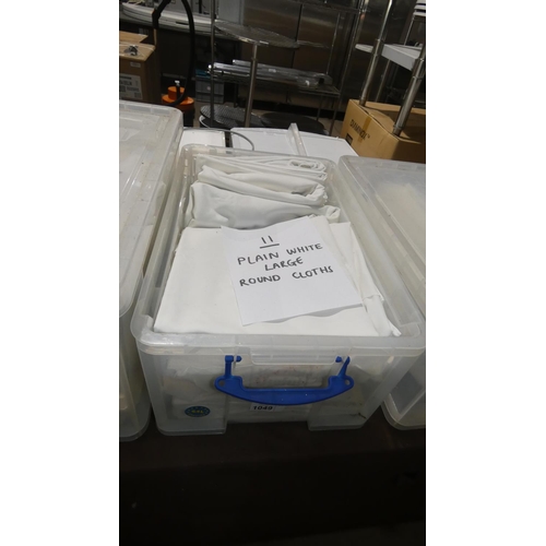 1049 - A quantity of 11 large round white table cloths, contents of 1 plastic crate