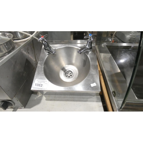 1063 - A stainless steel hand sink with taps