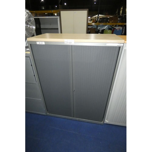 1221 - 1 grey metal tambour front storage cabinet with light wood effect top approx 100 x 47 x 133cm high