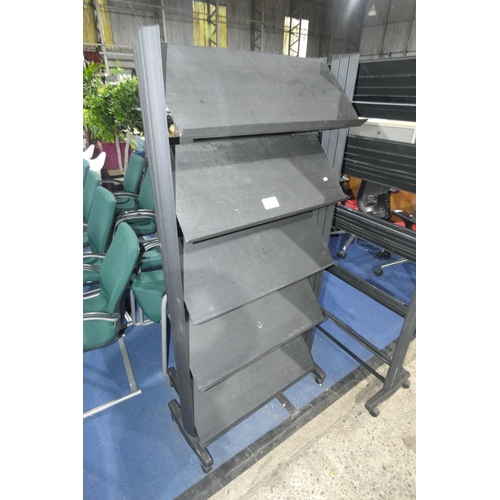 1282 - 2 wheeled black plastic magazine / literature display racks each approx 80cm w x 166cm high