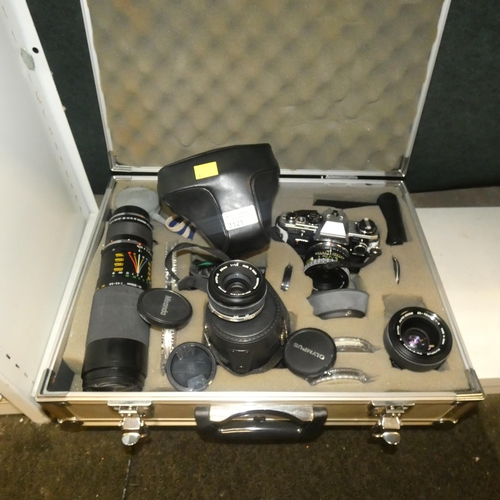 3121 - A metal carry case containing a vintage Olympus OM-10 camera with 1 x Olympus 35-70mm lens, 1 x Olym... 