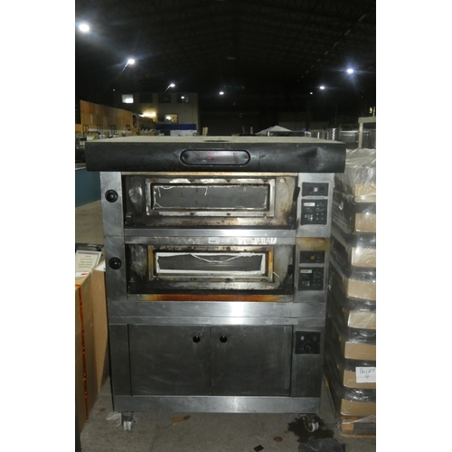 1025 - A large commercial stainless steel pizza oven by Moretti Forni with 2 ovens on a 2 door heated cabin... 