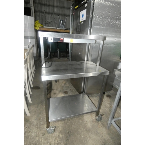 1292 - A mobile commercial stainless steel catering type table with shelf beneath and heated gantry above a... 