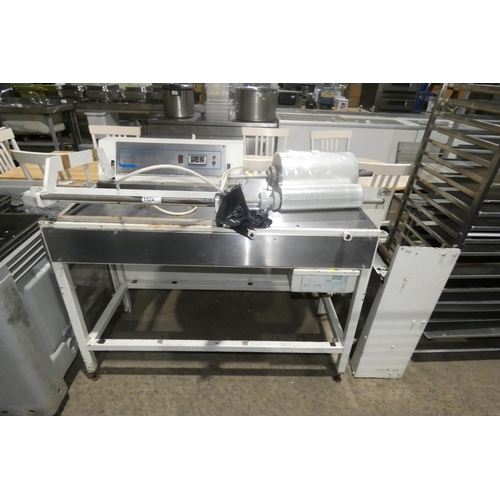 1324 - A commercial stainless steel packaging machine with rolls of wrap, heat sealer etc. REQUIRES ATTENTI... 