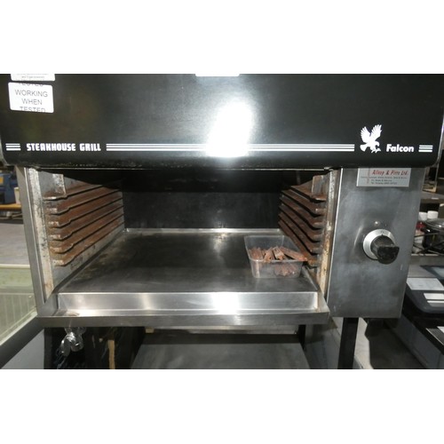 1283 - A gas fired steakhouse grill by Falcon, comes on a stand with 2 shelves below, some stones require r... 