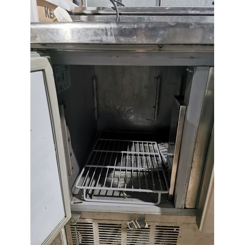 1267 - A commercial stainless steel 3 door bench fridge with salad/pizza prep bar by Blizzard (on button re... 