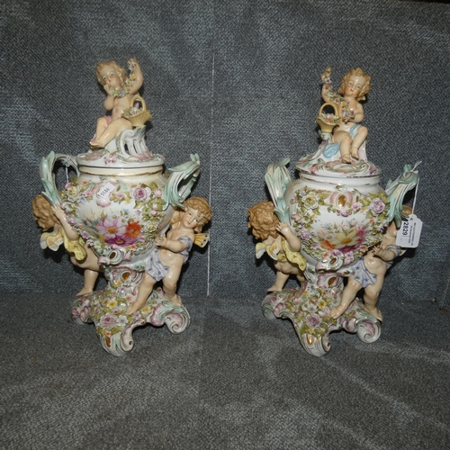 2829 - A pair of Sitizendorf porcelain pot pourri urns with covers, winged cupid and floral encrusted decor... 