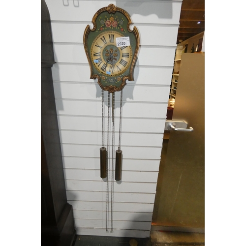 2920 - A green and floral decorated wall clock with exposed pendulum and weights